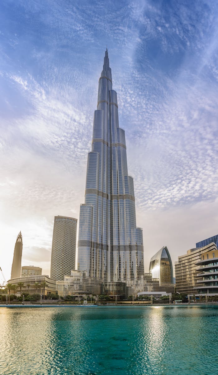 Majestic Burj Khalifa against a bright blue sky reflecting in water, Dubai.